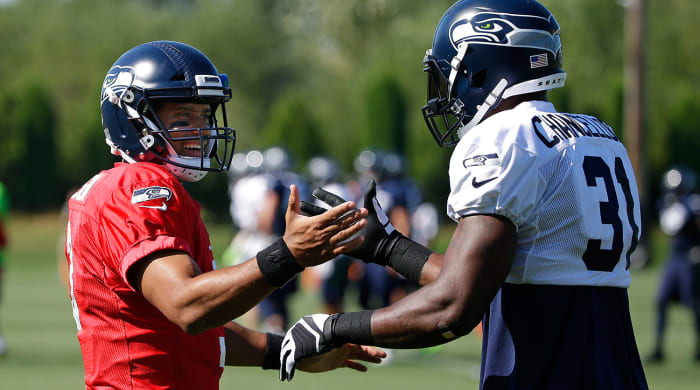 Russell Wilson and Kam Chancellor embrace in a more friendly moment during Tuesday’s otherwise testy practice.